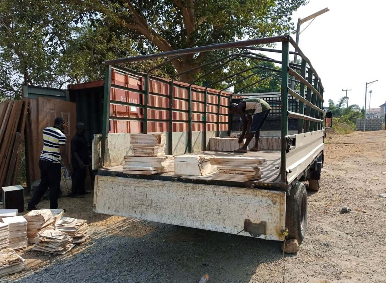 Workers loading materials onto a Korlun Canter flatbed truck