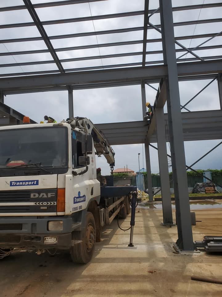 Korlun crane truck lifting a steel beam at a construction site